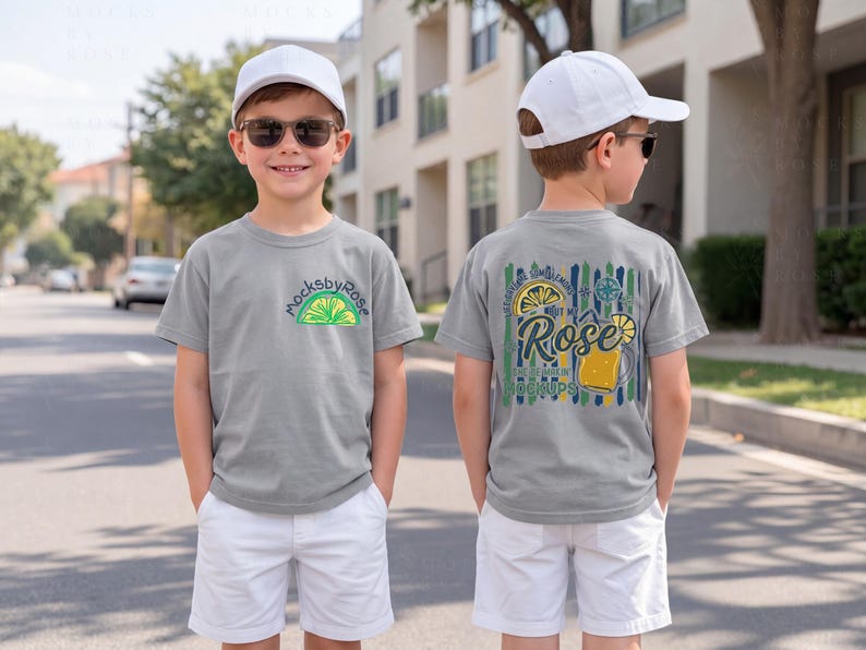 May include: A young person wearing a gray t-shirt and white shorts. The front of the shirt has a lime graphic and the text "mocksbyrose". The back of the shirt has a graphic with a lemon, a beer mug, and the text "Rose Mockups".