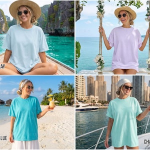 May include: Four images showcasing women wearing oversized t-shirts in various colors: Chambray, Orchid, Lagoon Blue, and Chalkmint. Each shirt has a relaxed fit and short sleeves. The women are in outdoor settings, with tropical and coastal backgrounds.