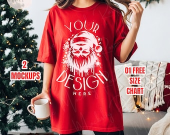 Könnte beinhalten: Rotes T-Shirt mit weißem Weihnachtsmann-Design und dem Schriftzug "YOUR DESIGN HERE". Das Bild ist ein Mockup, mit dem Text "2 MOCKUPS" und "01 FREE SIZE CHART" sichtbar. Eine weiße Tasse wird in der Hand gehalten.