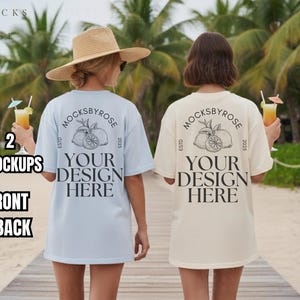 以下が含まれることがあります： ライトブルーとクリーム色の2枚のオーバーサイズTシャツ。背中には円形のロゴと「YOUR DESIGN HERE」の文字がデザインされています。これらのシャツはデザイン配置用のモックアップです。画像には「2 MOCKUPS FRONT + BACK」というテキストが含まれています。