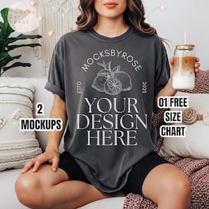 May include: A charcoal gray t-shirt with the text "YOUR DESIGN HERE" and the brand name "MOCKSBYROSE" in white. The shirt features a lemon graphic and the text "ESTD 2025". The image also includes a glass with a lid and a drink.