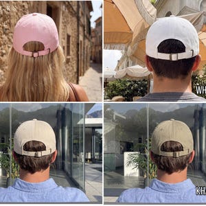 May include: Four baseball caps in pink, white, stone, and khaki. Each cap has a curved brim and an adjustable metal buckle closure. The caps are displayed from the back, showcasing the color variations.
