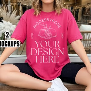 May include: A magenta t-shirt with a round graphic of lemons and the text "MOCKSBYROSE ESTD 2025 YOUR DESIGN HERE." The model is wearing black shorts and white sneakers. A clear plastic cup with a brown beverage is in the model's hand.