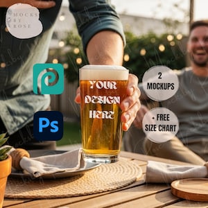 May include: A clear pint glass filled with beer, held by a person. The glass has the text "YOUR DESIGN HERE" printed on it. The image also includes the text "2 MOCKUPS" and "+ FREE SIZE CHART".