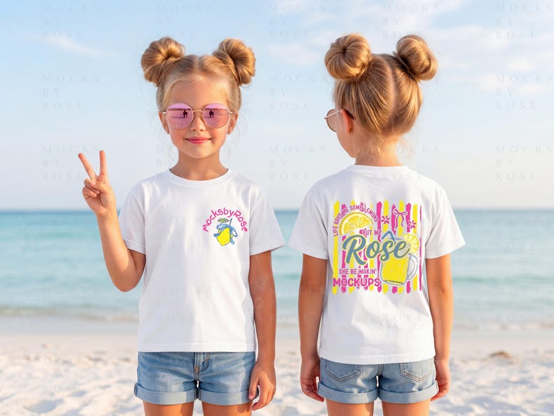 May include: Two white t-shirts with colorful graphics. One shirt has a small lemon design and the text "mocksbyrose". The other shirt has a lemon and drink graphic with the text "Rose" and "She be mixin' mockups". The shirts are worn by a child on a beach.
