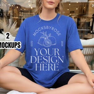 Pode incluir: Uma t-shirt azul com o texto branco "YOUR DESIGN HERE" e um desenho de limão. A t-shirt faz parte de um conjunto de maquetas. A modelo usa calções pretos e sapatos brancos.