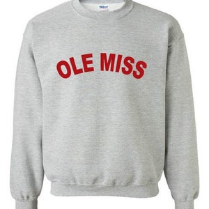 Op de afbeelding: Een lichtgrijs sweatshirt met de tekst "OLE MISS" in rode blokletters over de borst. De sweatshirt heeft een ronde hals en lange mouwen met geribde manchetten en zoom. De stof lijkt een zacht, comfortabel materiaal te zijn.