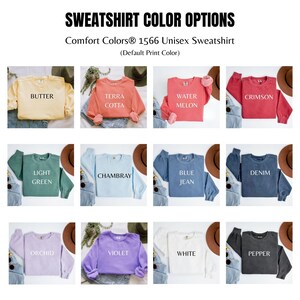 May include: A display of Comfort Colors 1566 Unisex Sweatshirts in various colors, including Butter, Terra Cotta, Water Melon, Crimson, Light Green, Chambray, Blue Jean, Denim, Orchid, Violet, White, and Pepper. Each sweatshirt is folded and paired with jeans and a hat.