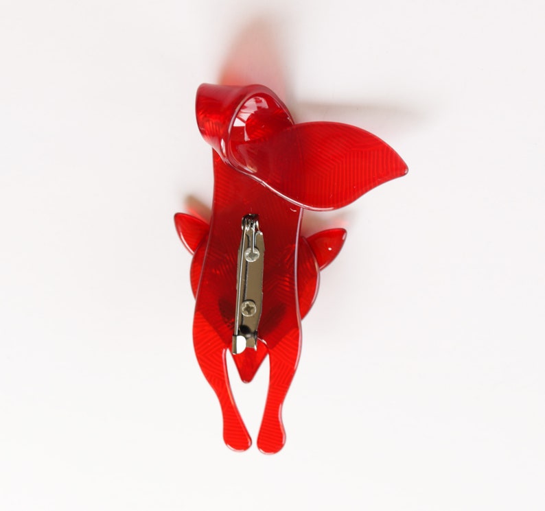 Puede incluir: Broche de zorro de pl&aacute;stico rojo con un alfiler en la parte posterior.