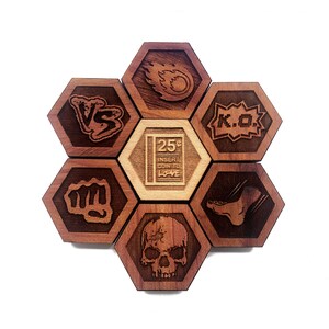 May include: A set of six hexagonal wooden game pieces with various designs, including a fist, a skull, a foot, a flame, the words "VS" and "K.O.", and the text "25¢ INSERT COIN TO LOVE".