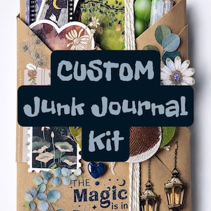May include: A brown paper envelope containing a junk journal kit with various paper ephemera, stickers, and decorative charms. The front features the text "CUSTOM Junk Journal Kit" and "THE Magic is in YOU" with illustrations of lanterns, flowers, and a butterfly.