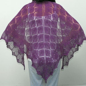 May include: A purple crocheted shawl with a lacy design. The shawl is draped over a person's shoulders and is made with a delicate, openwork pattern.