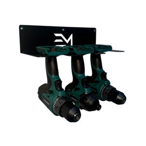 May include: A black metal drill holder with three green and black cordless drills. The holder has a shelf for the drills and a mounting plate with a white logo. The drills are arranged side by side.