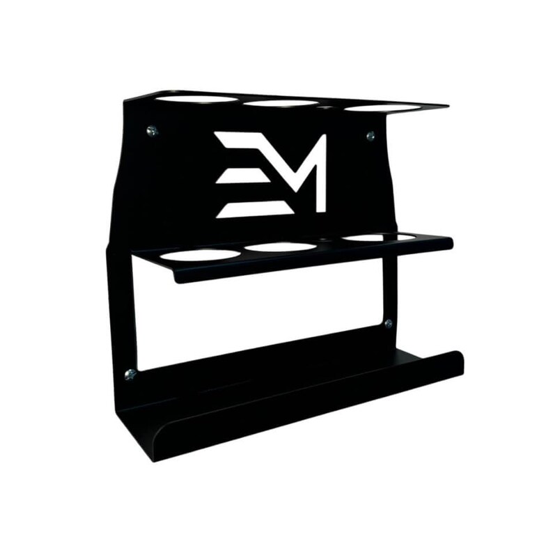 May include: Black metal wall-mounted organizer with three circular openings on top, three on the middle shelf, and a curved bottom shelf. The design includes a white logo with the letters "EM".