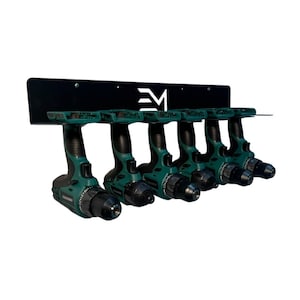 May include: A black metal drill holder with six green and black cordless drills. The holder has the letters "EM" in white. The drills are arranged in a row, ready for use. The background is white.
