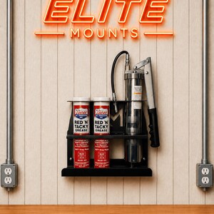 May include: A black metal wall-mounted shelf holding two red and white Lucas Red 'N' Tacky Grease cans, two smaller cans, and a grease gun. The neon sign above reads "ELITE MOUNTS". The background is a light wood-paneled wall.