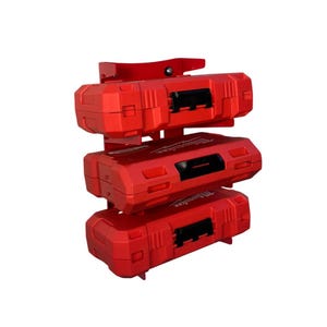 May include: A red metal wall mount with three red tool battery cases. The cases are stacked on top of each other. The cases have the word "Milwaukee" printed on them.