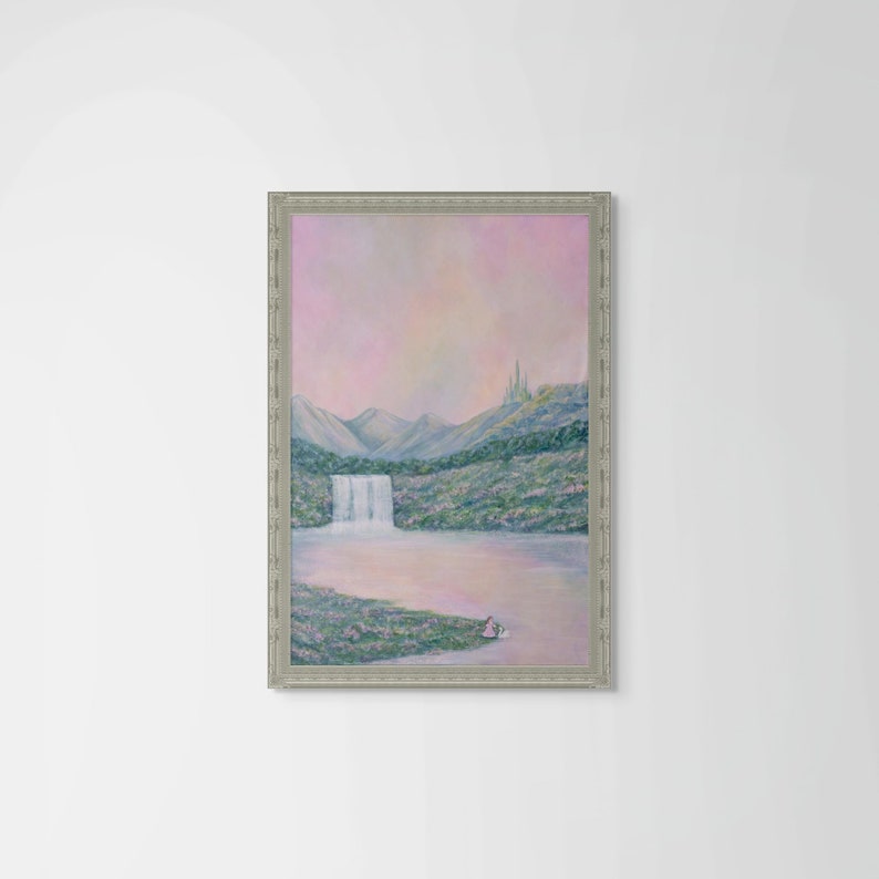 May include: A framed landscape painting depicts a waterfall cascading into a lake, with mountains in the background. The artwork features a soft color palette of pink, blue, and green, with a castle on a distant hill. The frame is silver.