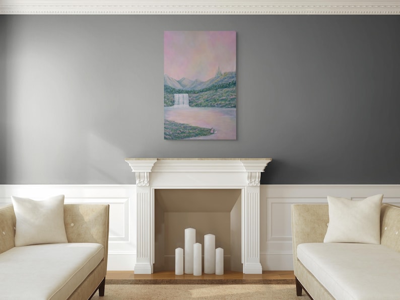 May include: An oil painting of a waterfall cascading into a lake, set against a backdrop of mountains and a pink sky. The artwork is displayed above a white fireplace, flanked by two beige chaise lounges.