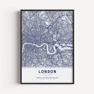 Puede incluir: Una impresión de arte enmarcada que presenta un mapa callejero detallado en azul oscuro de Londres, Inglaterra. El mapa muestra el río Támesis serpenteando por la ciudad. Debajo del mapa, el texto dice LONDON, UNITED KINGDOM, y London was never finished. That was the plan.
