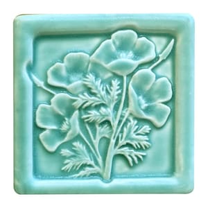 Puede incluir: Azulejo de cerámica turquesa cuadrado con un relieve en relieve de flores de amapola y follaje. El azulejo tiene un borde ligeramente redondeado y un acabado liso y brillante. El diseño floral es detallado y elegante.
