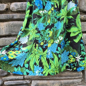 May include: A black, green, and blue floral print skirt with a gathered waist.