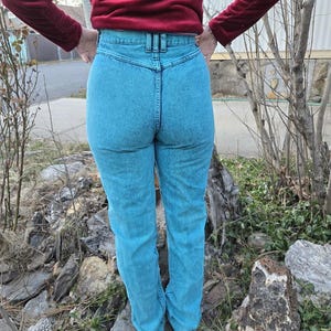 May include: A pair of high-waisted light blue denim jeans with a dark blue waistband.