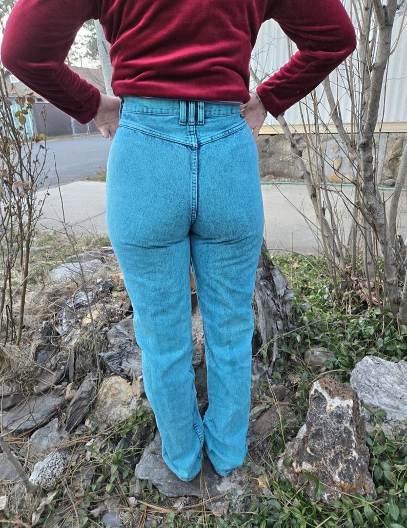 May include: A pair of high-waisted light blue denim jeans with a dark blue waistband.