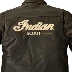 May include: A brown leather jacket featuring the word "Indian" in cream script across the back, with "SCOUT" below. The jacket has a button-down collar and buttoned cuffs. The leather has a worn appearance.