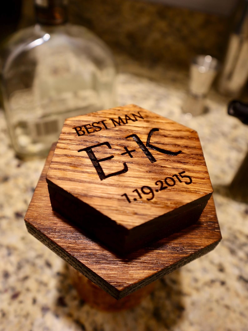 Pu&ograve; includere: Una scatola di legno esagonale con le parole "Best Man" e "E+K" incise sul lato superiore. La data "1.19.2015" &egrave; incisa anche sulla scatola.