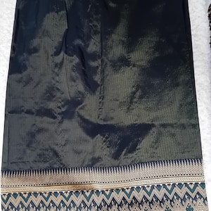 May include: A black and green skirt with a gold and green embroidered border. The skirt is made of a silky fabric.