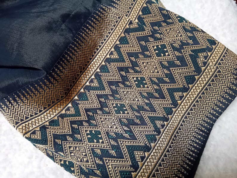May include: Black fabric with a gold and green geometric pattern. The fabric has a woven texture and a subtle sheen.