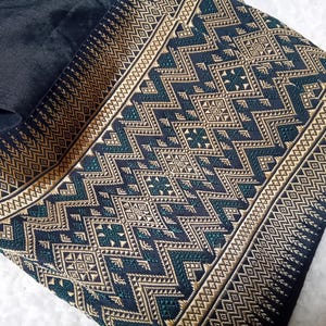 May include: Black fabric with a gold and green geometric pattern. The pattern is woven into the fabric and features a variety of shapes, including squares, triangles, and diamonds.