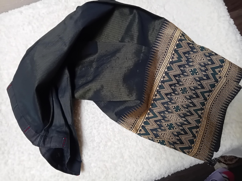 May include: A black and gold patterned fabric with a geometric design. The fabric is folded in half and has a dark green and gold trim.