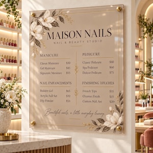 May include: A rectangular acrylic sign for Maison Nails, Nail & Beauty Studio, featuring a beige background with black text and floral illustrations. The menu lists services like Manicure, Pedicure, Nail Enhancements, and Finishing Touches with prices in dollars.