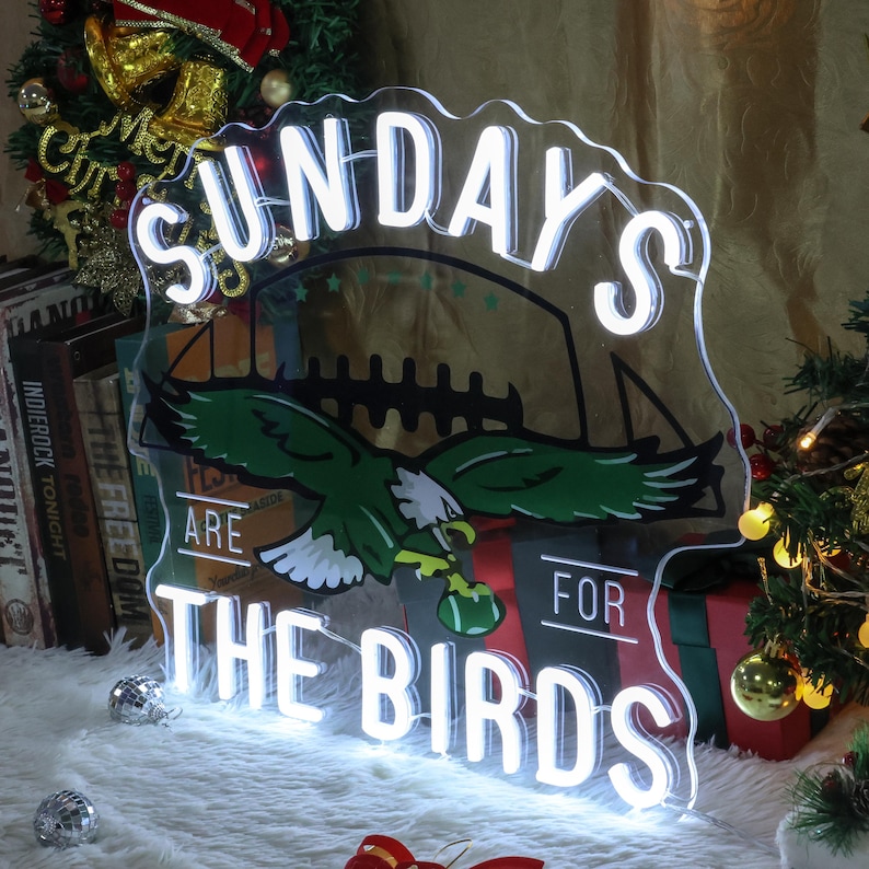 Może przedstawiać: Biały neonowy znak z tekstem "Sundays Are For The Birds" z zielono-czarnym logo Philadelphia Eagles w tle.