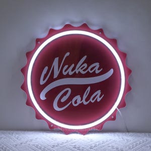 FalloutのNuka Colaをテーマにした金属製サインとボトルキャップデザインの壁装飾セット。 FalloutのNuka Colaをテーマにした金属製サインとボトルキャップ