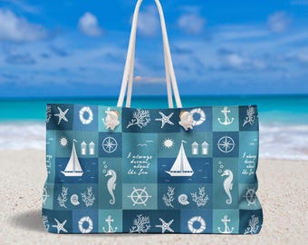 Puede incluir: Un bolso tote grande con temática náutica, con un diseño de patchwork de anclas, veleros, estrellas de mar e hipocampos en tonos azules y blancos. El bolso tiene un asa de cuerda blanca y el texto "I always dream about the sea".