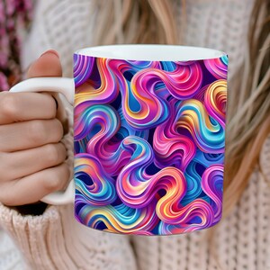May include: A white ceramic mug with a colorful abstract design featuring swirling, 3D-like shapes in shades of pink, blue, yellow, and purple.