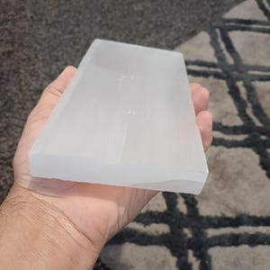 Può includere: Una piastra di ricarica in selenite bianca, un pezzo liscio e rettangolare di cristallo di selenite, utilizzato per purificare l'energia e ricaricare i cristalli.