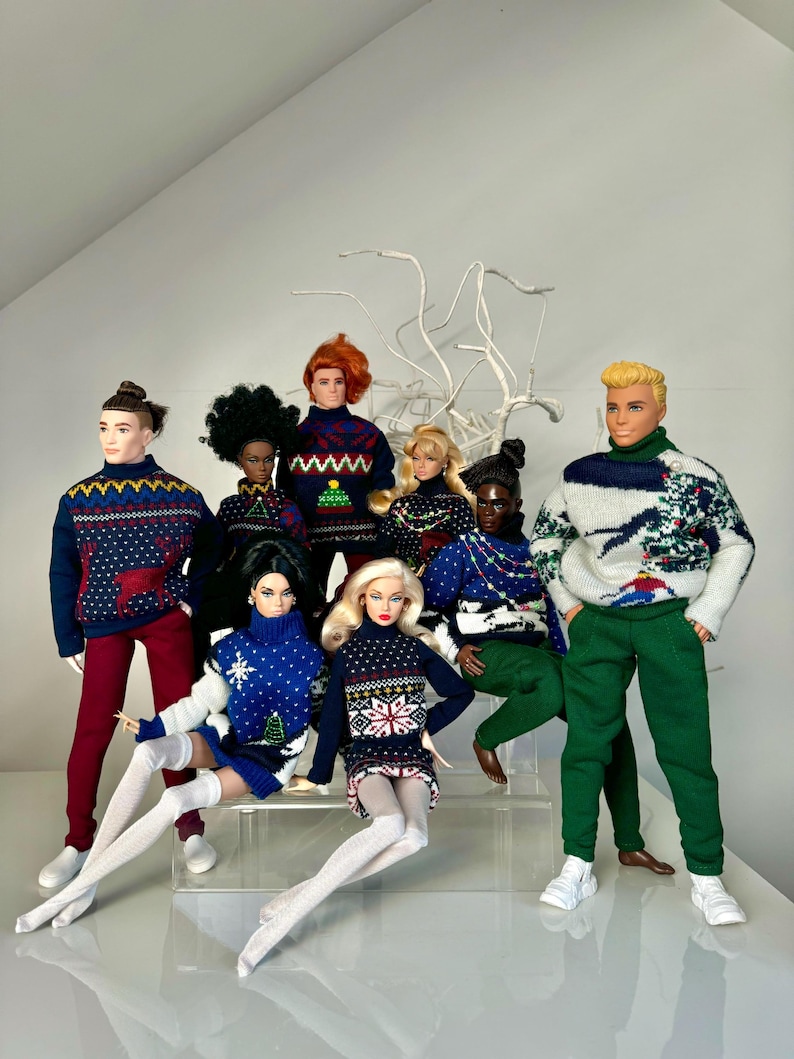 May include: A group of dolls wearing festive holiday sweaters with various patterns, including reindeer, snowflakes, and Christmas trees. The dolls are posed in a playful and festive manner, creating a cheerful holiday scene.