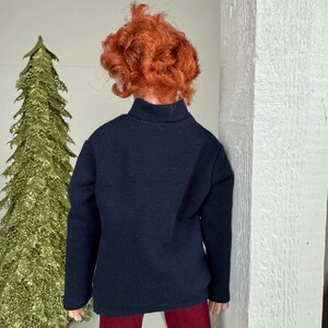 May include: A black long-sleeved shirt with a mock neck and red pants.