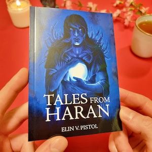 May include: A blue book cover with a dark figure holding a glowing orb. The title "Tales from Haran" is written in white letters with the author's name "Elin V. Pistol" below.