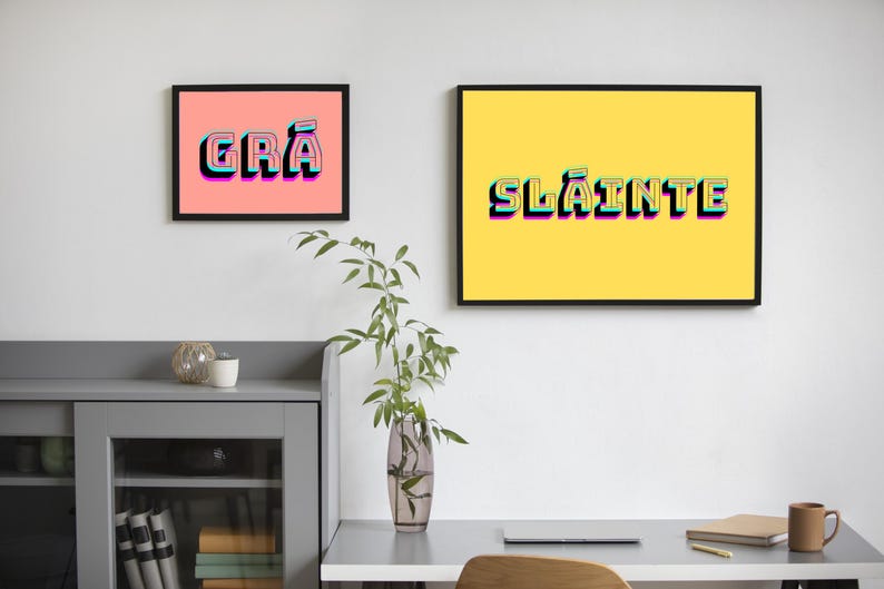 May include: Two framed prints with colourful text. The print on the left has a pink background and says "GR&Aacute;". The print on the right has a yellow background and says "SL&Aacute;INTE".