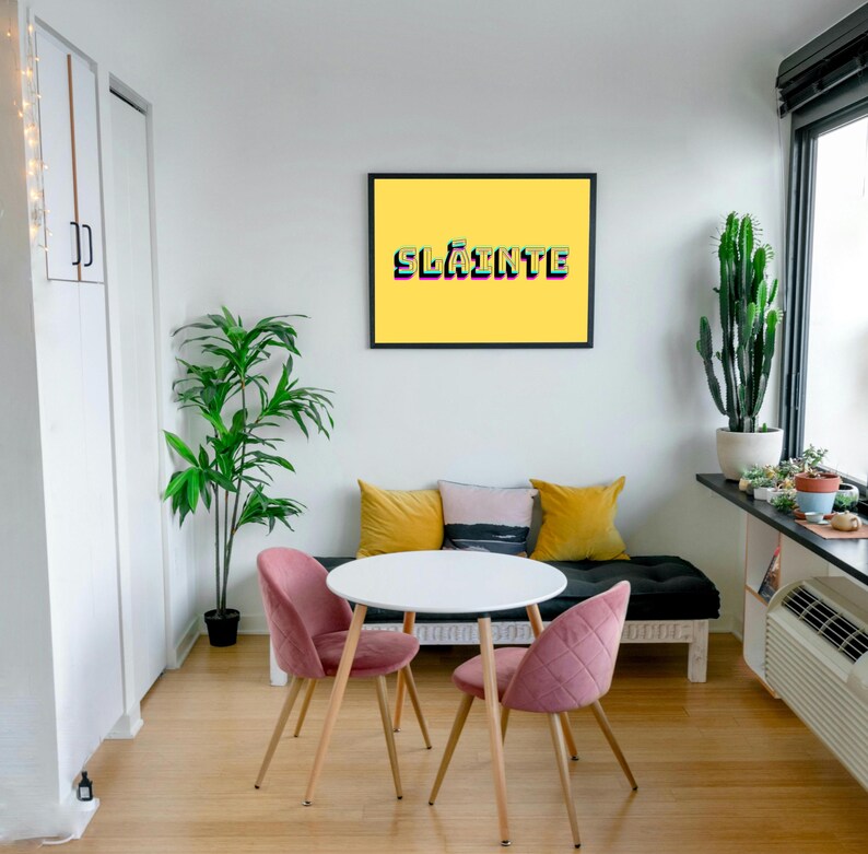 May include: A white table with two pink chairs and a black bench with yellow and black cushions. A framed print with a yellow background and the word "Sl&aacute;inte" in rainbow colours hangs on the wall.