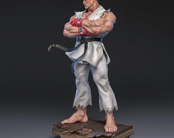 Puede incluir: Figura detallada de un personaje musculoso con uniforme blanco de artes marciales, guantes rojos y diadema roja. La figura está sobre una base de madera con los brazos cruzados, mostrando una expresión decidida. Un cinturón negro está atado a la cintura.