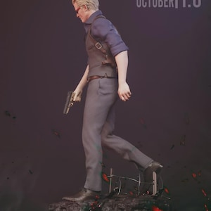 May include: A detailed action figure of a man in a dark blue shirt, gray vest, and pants, holding a gun. The figure has blonde hair and red-tinted glasses. The figure is standing on a rocky base with the text "YOUNGBLOOD SCULPTURE OCTOBER 1:6 SCALE".