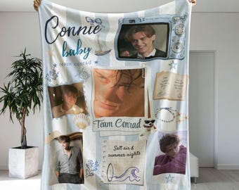 May include: A light blue and white striped fleece blanket featuring a collage of photos of a young man, the text "Connie baby", "team conrad", and "Salt air & summer nights", along with illustrations of a sailboat, seashell, and ocean waves.