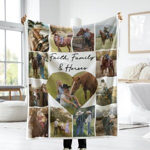 May include: A white fleece blanket with a photo collage of people with horses. The blanket has a heart-shaped photo in the center and the words "Faith, Family & Horses" in black script.
