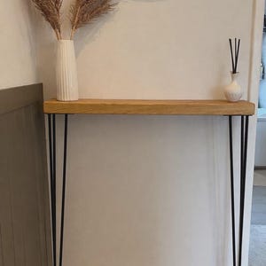 May include: A distressed wooden sign, reading "Welcome to our home" in white lettering. The sign has a rustic finish, ideal for adding a welcoming touch to any home's entrance.